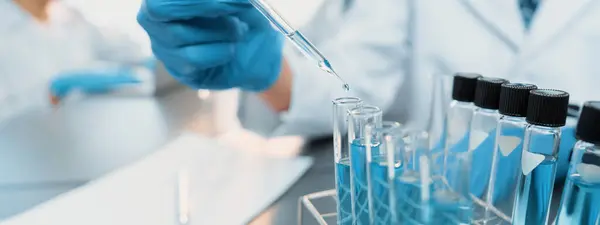 一组专职的科学家在医学实验室进行化学实验 小心地将准确数量的液体从吸盘滴入试管 用于疫苗药物或抗生素的研发 新时代 — 图库照片