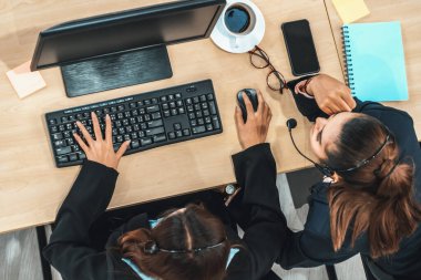 Ofiste bilgisayar başında çalışan, kulaklık takan iş adamları. Jivy