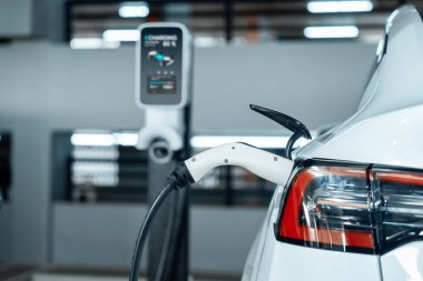 Alış veriş merkezinin otoparkında EV elektrikli araba şarjı şehir merkezindeki sürdürülebilirlik yaşam tarzını yeşil, temiz, yeniden şarj edilebilir elektrikli araç iç organları ile gösteriyor.