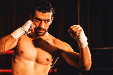 Üstsüz boksör pozu veren, beyaz boksör yumruğunu yumruklayıp kameranın önüne geçiyor, agresif duruşunu takınıyor ve boks ringinde dövüşmeye hazır. Impetus