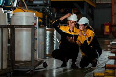 İki fabrika işçisi veya mühendis, kimya fabrikası, kimya fabrikası işyeri ve endüstriyel meslek konseptinde makine veya prosedür üzerinde profesyonel teftiş yürütüyor. Örnek gösteriliyor