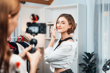 Kadın Etkilenen Vlog video görüntülerini sosyal medya ya da blog 'da en üst düzeyde yayınlıyor. Kozmetik stüdyosu ışıklandırmalı mutlu genç kız çevrimiçi pazarlama oturumu yayını için..