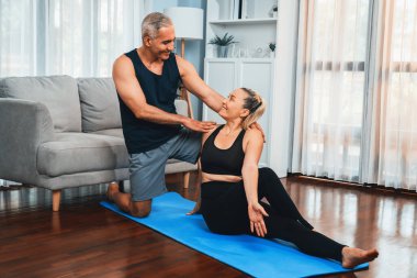 Spor giyim sektöründe aktif olan mutlu çift destekleyici ve evde yoga duruşunda birlikte yardımcı oluyorlar. Yoga egzersizi yapan sağlıklı bir erkek ve kadın yaşam tarzı. Etki