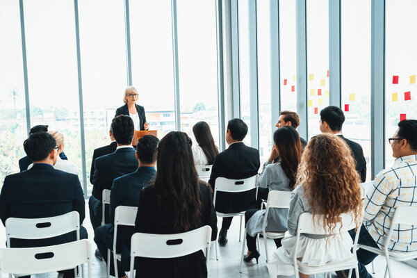 Встреча группы деловых людей на семинаре. Аудитория слушает инструктора на тренинге по обучению сотрудников. Форум сообщества офисных работников с экспертным докладчиком. Дживи