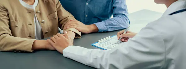 Doctor Providing Compassionate Healthcare Consultation While Young Couple Patient Holding — Stock Photo, Image