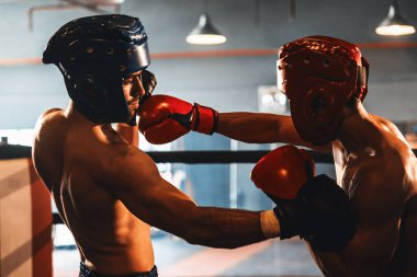 Kasklı iki atletik ve kaslı vücut boksörü ya da boks baş muhafızı vahşi bir boks maçında karşı karşıya. Boks dövüşçüsü boks ringinde dövüşüyor. Impetus