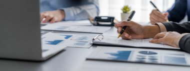 İş zekası ve veri analizi kavramı. İş stratejik planlamasının pazarlama göstergesi olarak kağıt üzerinde finansal veri analizi üzerinde çalışan bir grup analist. İçgörü