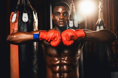 Boks dövüşçüsü, Afro-Amerikan siyah boksör elini veya yumruğunu agresif bir duruşla öne koydu ve boks çantası ve boks ekipmanıyla spor salonunda dövüşmeye hazırdı. Impetus