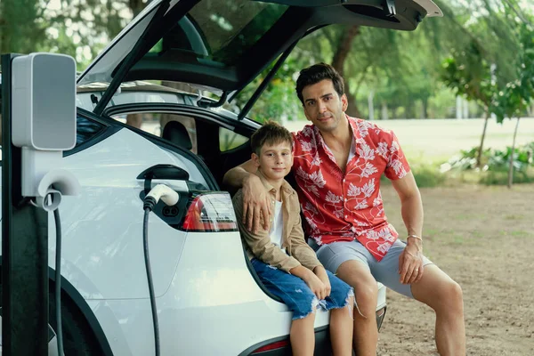 Οικογενειακές Διακοπές Ταξίδι Ηλεκτρικό Όχημα Πατέρας Και Γιος Επαναφόρτιση Αυτοκίνητο — Φωτογραφία Αρχείου