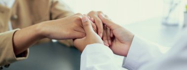 Doktor, doktor kliniğinde destekleyici ve profesyonel olduğu için genç hasta elini tutarken tıbbi teşhis raporunu ve şefkatli bir sağlık hizmeti danışmanlığı sunduğunu göster. Neoterik