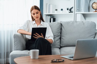Klinikteki psikolog kadın. Profesyonel portresi. Dostane gülümsemesiyle hastayı psikoloğa davet ediyor. Tecrübeli ve kendine güvenen psikolog son derece uzmandır.
