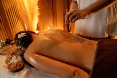 Lüks spa salonlarında sıcak mum ışığında cilt bakımı yaptıran kadın müşteri. Sağlık Spa vücut fırçasında tuz temizleme güzellik tedavisi. Sessiz.