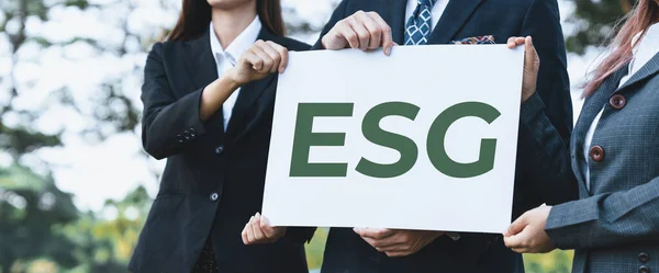 Group of business people stand united, holding eco-friendly idea and concept for environmental awareness campaign and embracing ESG principle for greener environment and sustainable future. Gyre