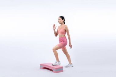 Çalışkan, enerjik bir kadın atölyede egzersiz yapıyor. Kardiyo aerobik hareketleriyle izole bir arka plan. Genç atletik Asyalı kadın mahareti ve dayanıklılık eğitimi konsepti.