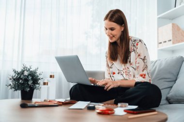 Genç mutlu kadın internetten alışveriş yaparak ürün satın alırken aynı zamanda internet üzerinden online ödeme sistemi ile çevrimiçi mağaza platformundan en yüksek siber güvenlik tarafından korunan ürünler sipariş ediyor.