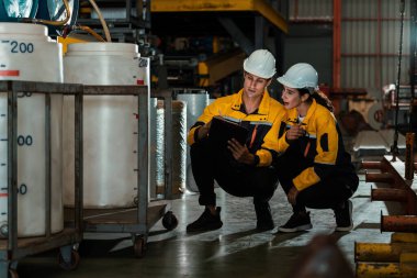 İki fabrika işçisi veya mühendis, kimya fabrikası, kimya fabrikası işyeri ve endüstriyel meslek konseptinde makine veya prosedür üzerinde profesyonel teftiş yürütüyor. Örnek gösteriliyor