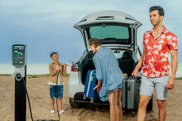 電気自動車でビーチで旅行する家族の休暇旅行 クリーンエネルギーでEvカーバッテリーを充電しながら 素敵な家族 環境に優しい車による代替家族旅行 — ストック写真