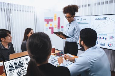 Genç Afrikalı iş kadını modern toplantıda TV ekranında veri analizi paneli sunuyor. Bir grup iş adamıyla konferans odasında iş sunumu. Uyum