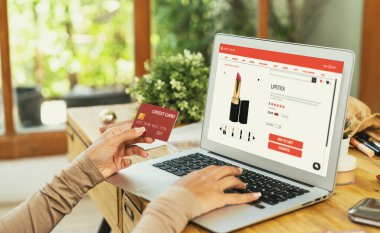İnternet pazarından alışveriş yapan kadın modern yaşam tarzı için satış malzemeleri arıyor ve önemli siber güvenlik yazılımları tarafından korunan cüzdandan çevrimiçi ödeme için kredi kartı kullanıyor