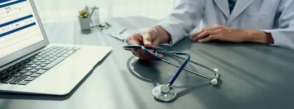 Arzt Mit Stethoskop Sorgfältig Prüfen Detaillierte Medizinische Bericht Mit Laptop — Stockfoto