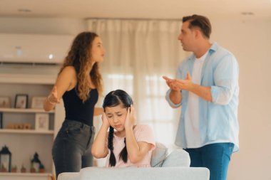 Sinirli ve mutsuz genç bir kız oturma odasında ebeveyninin tartışması yüzünden gerginliğin ortasında kanepede oturuyor. Sağlıksız ev hayatı ve travmatik çocukluk depresyona dönüşür.