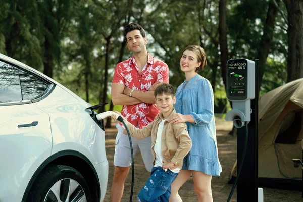 アウトドアアドベンチャーと家族旅行キャンプ 持続可能な未来のためのエコフレンドリーな車で自然旅行 キャンプ場のEv充電ステーション付きの素敵な家族の充電Ev車 パーペチュアル — ストック写真
