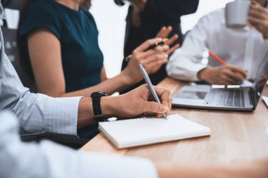 Sekreter, toplantı odasında görüşen bir grup çok ırklı iş adamıyla şirket toplantısında defterine not alıyor. Modern ofiste profesyonel toplantılarda çeşitlilik. Uyum