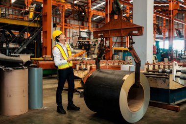 Makine operatörü çelik üretim makinelerini ustalıkla çalıştırıyor, metal fabrikasındaki ağır inşaat mühendisliği malzemeleri için silindir rulo çelik üretiyor. Örnek gösteriliyor