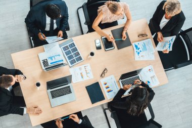 İş adamları grup toplantısı ofiste yukarıdan çekildi. İş kadınları, iş adamları ve ofis çalışanları toplantı masasında proje planlama belgeleriyle takım konferansında çalışıyorlar. Jivy
