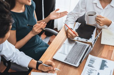 Çok ırklı analist ekibi toplantı masasındaki finansal verileri analiz etmek için BI Fintech yazılımı kullanıyor. Finansal konsol veri ekranında pazarlama göstergesi için analiz edilmiş grafikle birlikte. Uyum
