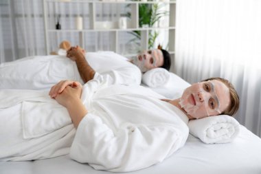 Kaplıca salonunun sakin, modern gündüz atmosferi, birkaç müşteri yüz maskesi takarak kendini yenilemeye çalışıyor. Yüz bakımı ve güzellik kozmetolojisi prosedürü. Sessiz.