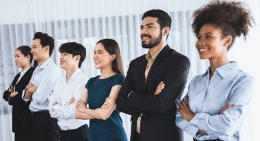 Profesyonel iş adamlarından oluşan çeşitli gruplar modern kurumsal ofiste çapraz kol hareketi ile sırada bekliyor. Mutlu ve gülümseyen, çok ırklı ofis çalışanı ekip birleşmesi ve birlikte başarılı. Uyum