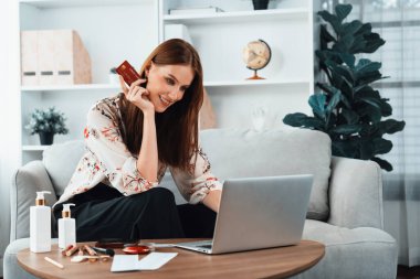 Genç mutlu kadın internetten alışveriş yaparak ürün satın alırken aynı zamanda internet üzerinden online ödeme sistemi ile çevrimiçi mağaza platformundan en yüksek siber güvenlik tarafından korunan ürünler sipariş ediyor.