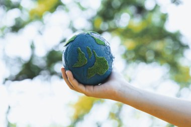 Dünya gezegenini ESG ilkesi ve çevre dostu enerjisiyle daha parlak bir gelecek için Dünya günü olarak el ele tutuşan genç çocuklar. Döngü