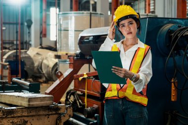 Profesyonel kalite kontrol müfettişi fabrikadaki makine ve imalat sürecinde güvenlik denetimi yapıyor. Kadın mühendis mekanik tesiste işlem optimizasyonunu denetliyor. Örnek gösteriliyor