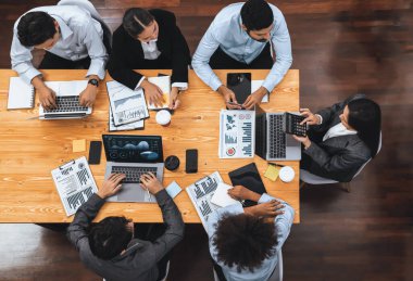 Panorama üst görüşlü çok ırklı analist ekibi, stratejik karar için finansal verileri analiz etmek amacıyla dizüstü bilgisayarda BI gösterge panelini kullanıyor. Fintech pazarlama göstergelerini analiz ediyor. Uyum