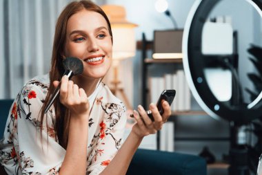 Kadın Etkilenen Vlog video görüntülerini sosyal medya ya da blog 'da en üst düzeyde yayınlıyor. Kozmetik stüdyosu ışıklandırmalı mutlu genç kız çevrimiçi pazarlama oturumu yayını için..