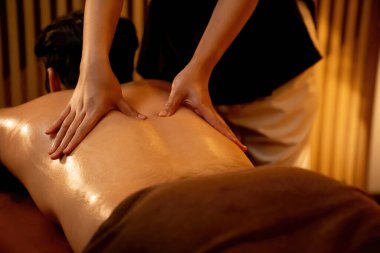 Beyaz erkek müşteri stres önleyici spa masajının keyfini çıkarıyor ve lüks otel ya da oteldeki ortam kaplıcalarında sıcak mum ışığında güzellik teniyle eğleniyor. Sessiz.