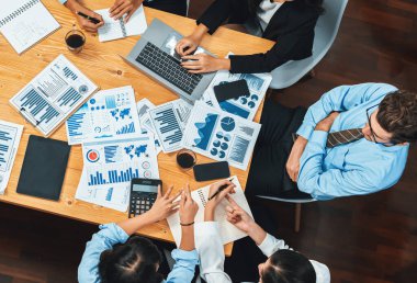 Üst düzey iş analist grubu toplantı masasındaki finansal veri raporunu analiz ediyor. İş zekası analizine göre çizelge ve grafik paneli. Çok titiz.