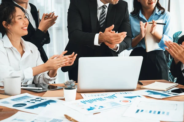 Group of happy businesspeople in celebratory gesture and successful efficient teamwork. Diverse race office worker celebrate after made progress on marketing planning in corporate office. Habiliment