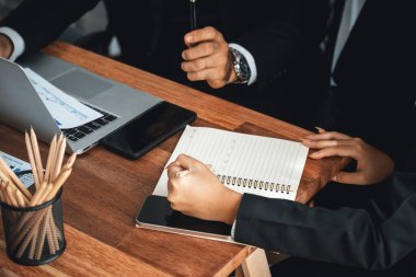 Proaktif iş kadını aktif olarak üretken iş toplantılarına katılıyor, stratejik pazarlama planlaması için mali veri tablosuyla birlikte iş arkadaşlarıyla fikir alışverişinde bulunuyor. Çok titiz.