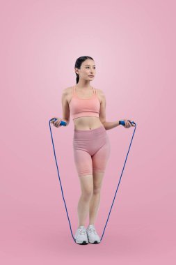 Spor giyim sektöründe genç enerjik Asyalı kadın atlıyor ya da atlıyor stüdyo çekimlerinde izole edilmiş arka planda portre pozu veriyor. Kardiyo egzersiz aleti ve sağlıklı vücut bakımı yaşam tarzı. Kuvvetli