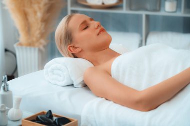 Kafkasyalı kadın müşteri stres önleyici spa masajının keyfini çıkarıyor ve lüks otel ya da oteldeki gündüz açık ortam güzellik salonunda güzellik teniyle eğleniyor. Sessiz.