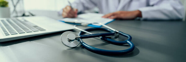 Фокус-стетоскоп на кабинете врача с размытым фоном просмотрения врачом медицинского заключения и диагностики заболеваний для эффективного плана лечения пациента. Неотвратимость