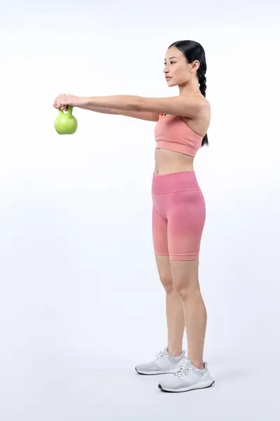孤立した背景で運動を持ち上げるケトルベル体重をしている活発な女性 ボディワークアウトルーチンとしての若い運動アジアの女性の強さと耐久トレーニングセッション — ストック写真