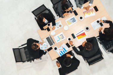 İş adamları grup toplantısı ofiste yukarıdan çekildi. İş kadınları, iş adamları ve ofis çalışanları toplantı masasında proje planlama belgeleriyle takım konferansında çalışıyorlar. Jivy