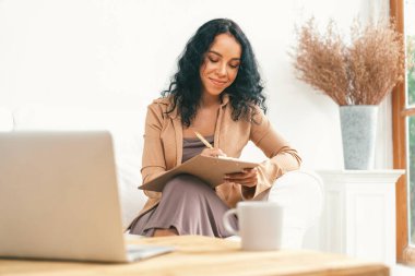 İnternette önemli bir iş için dizüstü bilgisayar kullanan Afro-Amerikalı bir kadın. Evde çalışan sekreter veya çevrimiçi içerik yazma.