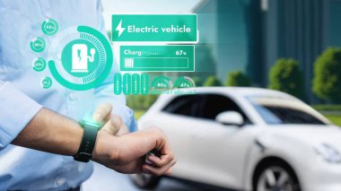 İş adamı, ESG yeşil parktan akıllı saat hologram şarj şarjının EV araba aküsü durumunu kontrol et. Modern şehir yaşam tarzı ve karbondioksiti azaltmak için çevre dostu elektrikli araba kullanımı. İnceleyin