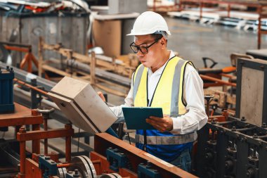 Fabrika mühendisi endüstriyel çelik oluşum makinesini teftiş ediyor. Metal makine mühendisliği denetim denetçisi olarak liderliği gösteriyor..