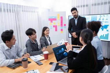 Pazarlama stratejisi için modern toplantıda veri analizi paneli ekranında sunan bir işadamı. Bir grup iş adamıyla konferans odasında iş sunumu. Uyum